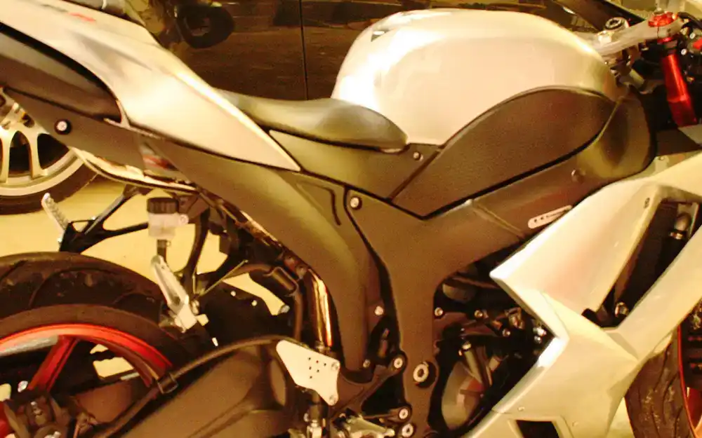 A street bike in a Client's garage next to a black Infiniti G35
